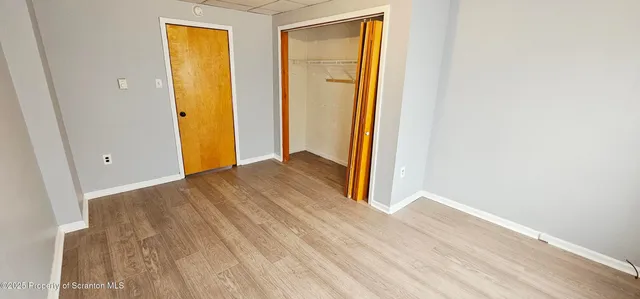 a view of a room with wooden floor