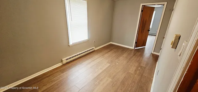a view of an empty room and wooden floor