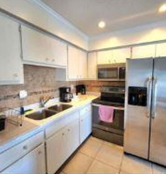 525 Manatee Court, Unit 13 Venice, FL 34285 - Photo 7 of 7 a kitchen with a refrigerator sink and cabinets
