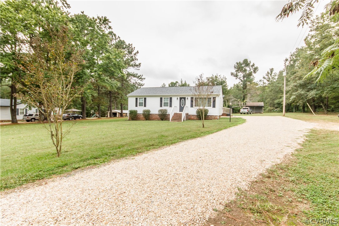a view of house with yard and trees in the background