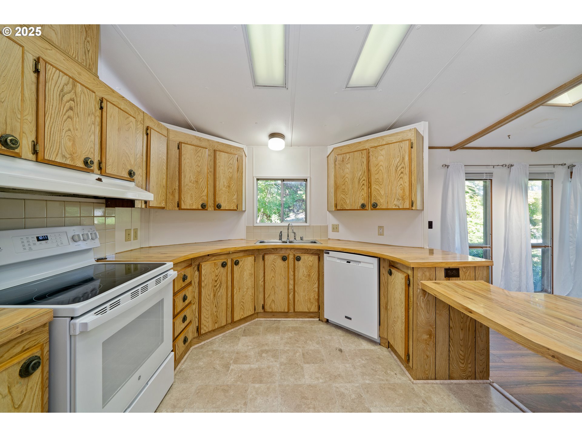 1057 Northeast 12th Avenue Rockaway Beach, OR 97136 - Photo 11 of 36 a large kitchen with stainless steel appliances granite countertop a sink and cabinets