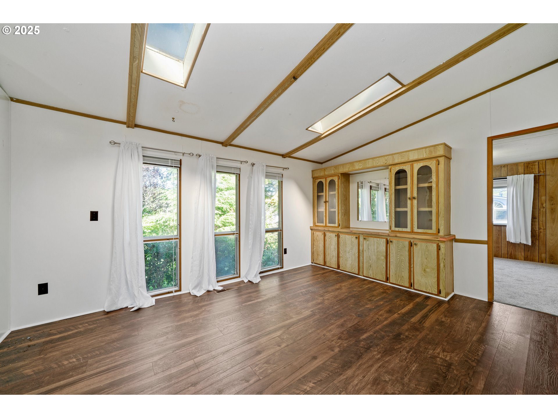 1057 Northeast 12th Avenue Rockaway Beach, OR 97136 - Photo 7 of 36 a view of an empty room with wooden floor and windows
