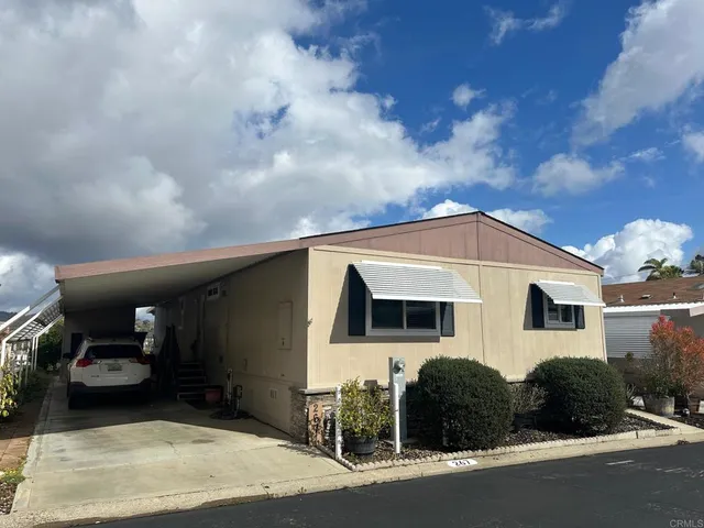 a front view of a house with yard and parking