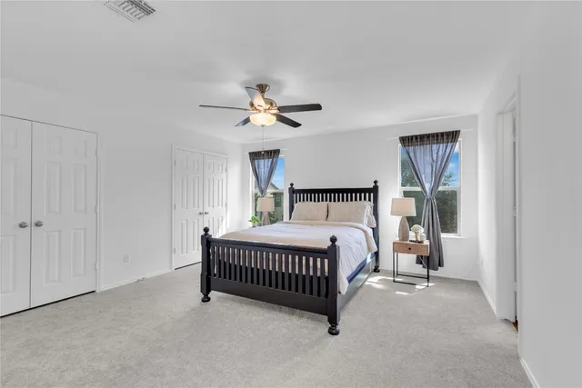 a bedroom with a bed and a ceiling fan
