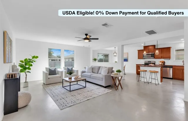 a living room with furniture kitchen view and a potted plant