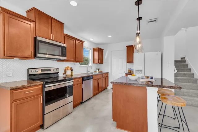 a kitchen with stainless steel appliances granite countertop a stove and a sink