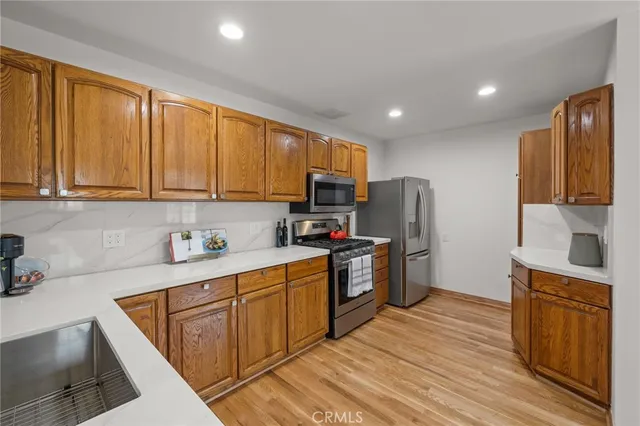 a kitchen with stainless steel appliances granite countertop a refrigerator stove top oven and sink