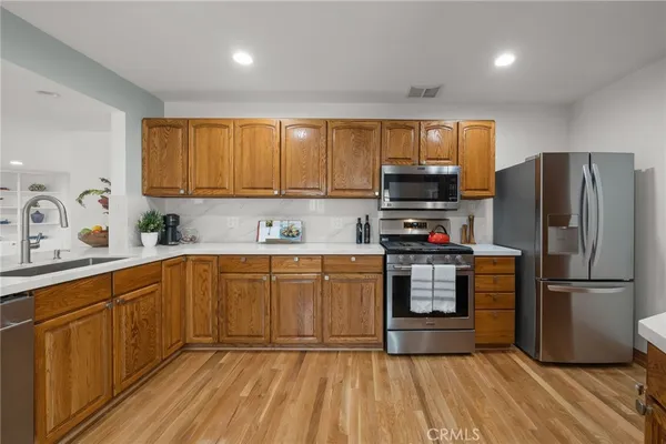 a kitchen with granite countertop a refrigerator stove top oven and sink