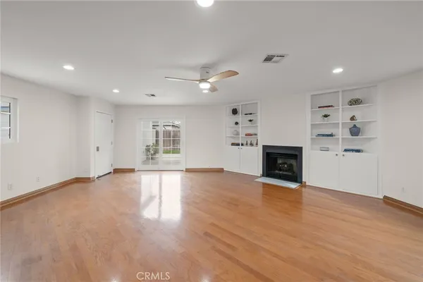 an empty room with wooden floor and fireplace