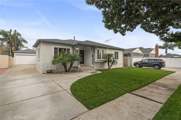 a front view of a house with a garden and table