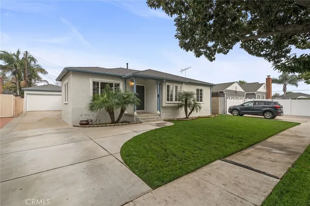 a front view of a house with a garden and table