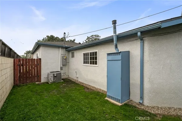 a brick house with a small yard and wooden fence