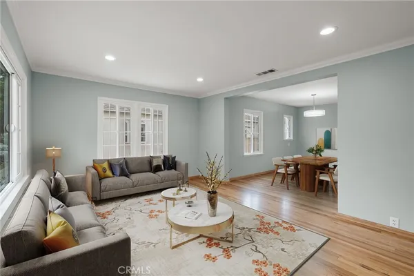 a living room with furniture and a wooden floor