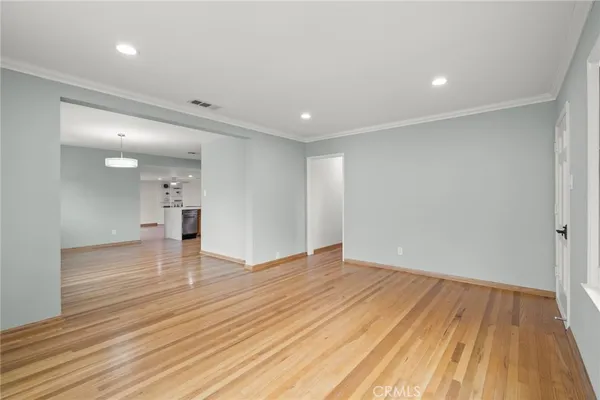 a view of empty room with wooden floor
