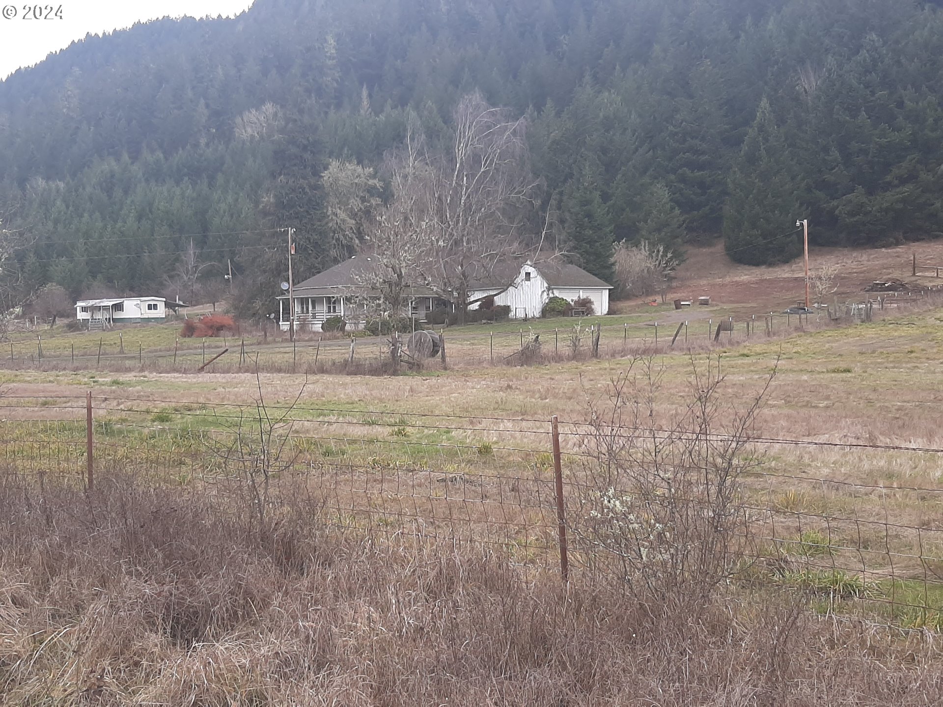 a view of a dry yard with wooden fence