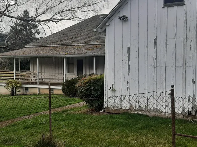 a view of a house with a small yard and wooden fence
