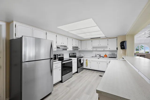 a kitchen with stainless steel appliances a refrigerator sink and wooden floor