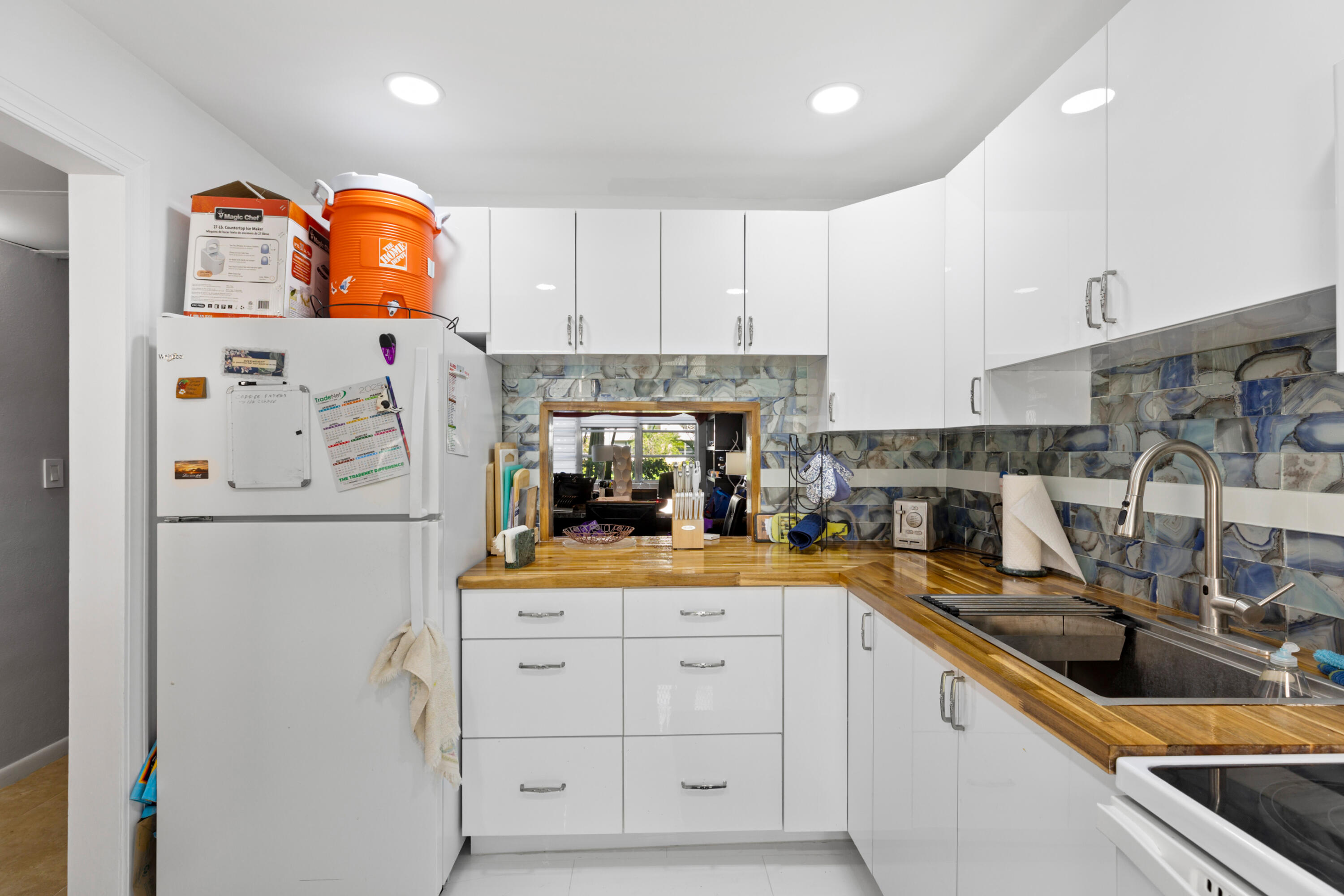 400 Northeast 20th Street, Unit B108 Boca Raton, FL 33431 - Photo 6 of 31 a kitchen with white cabinets and refrigerator