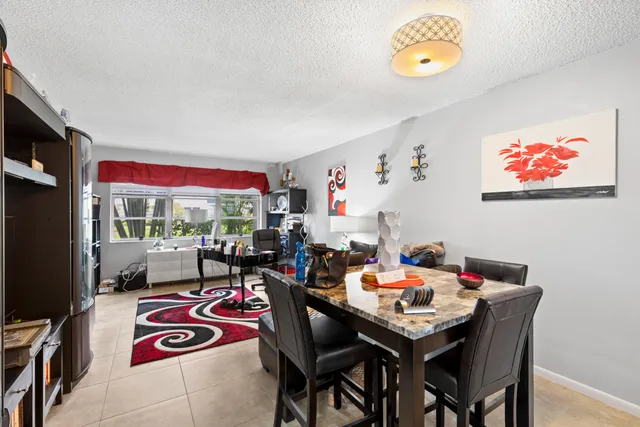 a view of a dining room with furniture one side kitchen view and wooden floor