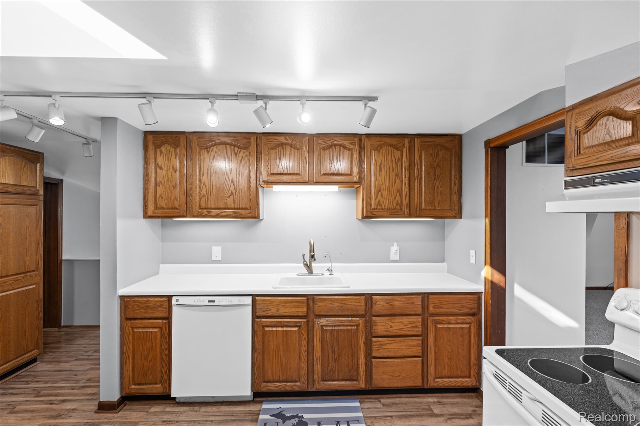 7670 Mi State Road Manchester, MI 48158 - Photo 22 of 53 Kitchen featuring brown cabinetry, white appliances, light countertops, and light wood-style floors