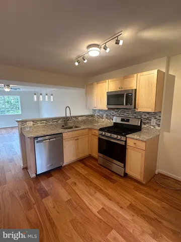 a kitchen with kitchen island granite countertop a sink cabinets and window