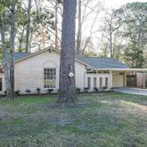 a view of a yard in front of a house with large trees