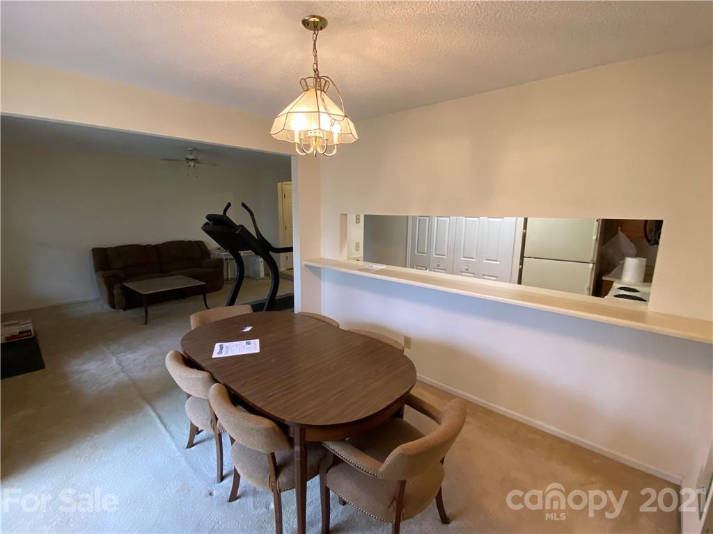 19839 Henderson Road, Unit A Cornelius, NC 28031 - Photo 12 of 23 a living room with furniture and a chandelier