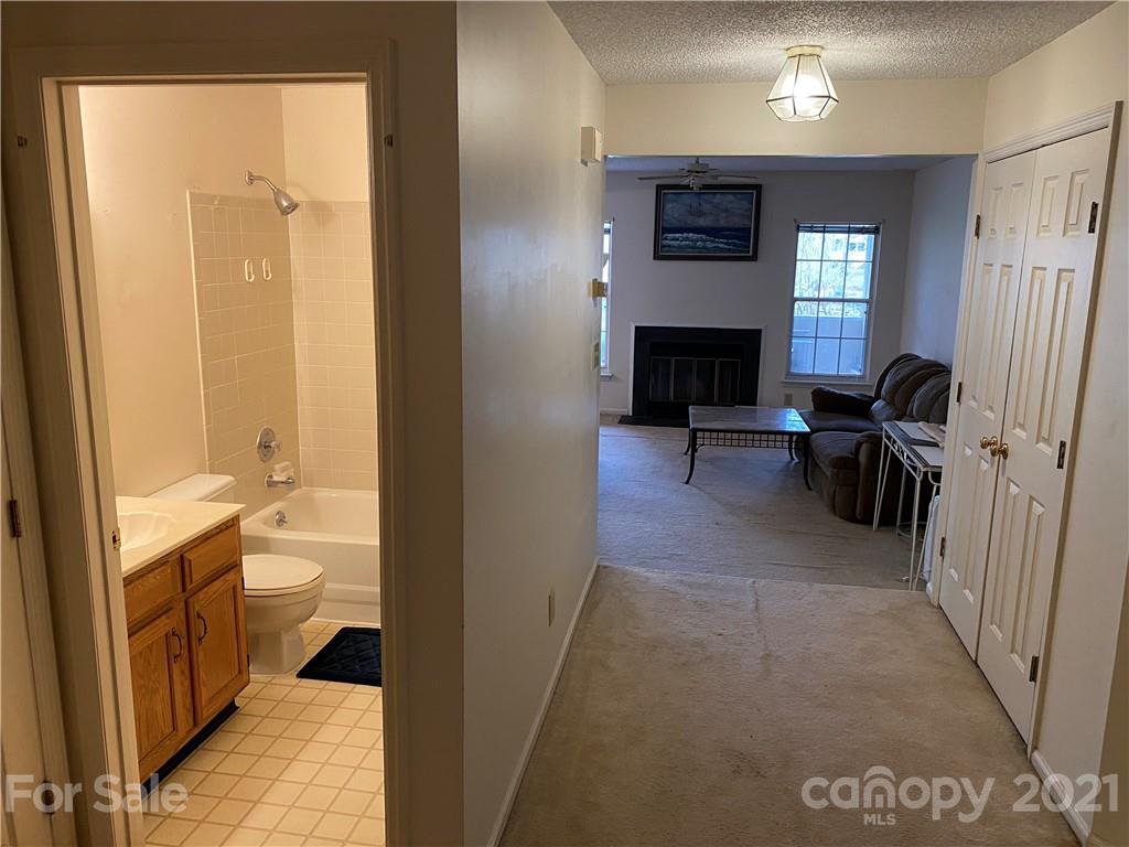 19839 Henderson Road, Unit A Cornelius, NC 28031 - Photo 6 of 23 a view of a hallway with bathroom and a fireplace