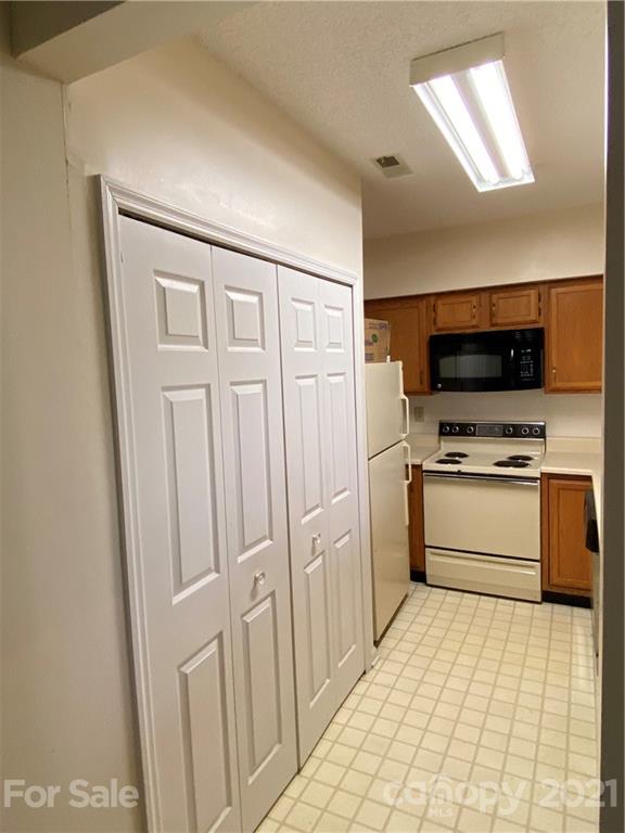 19839 Henderson Road, Unit A Cornelius, NC 28031 - Photo 8 of 23 a kitchen with white cabinets and appliances