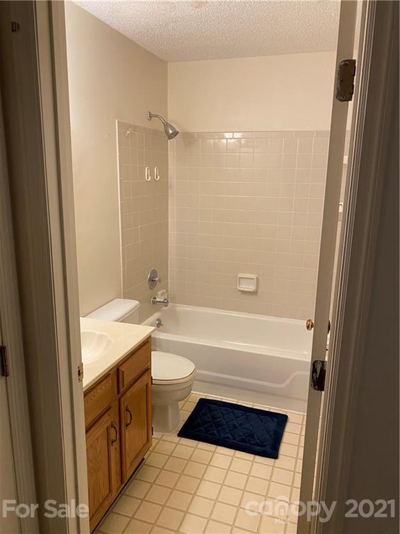 19839 Henderson Road, Unit A Cornelius, NC 28031 - Photo 9 of 23 a bathroom with a granite countertop bathtub shower sink vanity and toilet