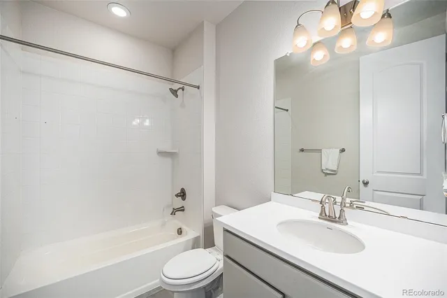 a bathroom with a sink a toilet a mirror a bathtub and shower