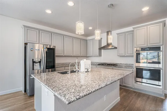 a kitchen with stainless steel appliances granite countertop a sink refrigerator and microwave
