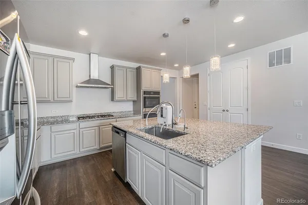 a kitchen with stainless steel appliances granite countertop refrigerator sink and cabinets