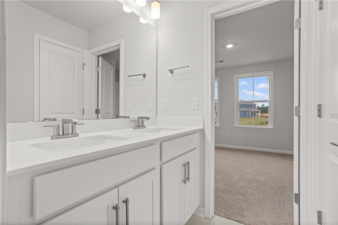 631 Sweetspire Trail, Unit 148 Seneca, SC 29678 - Photo 22 of 36 Double vanity sinks and bright lighting enhance this well-appointed primary bathroom.