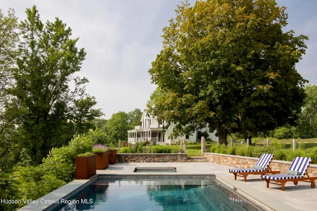 a view of a swimming pool with lawn chairs and a fire pit