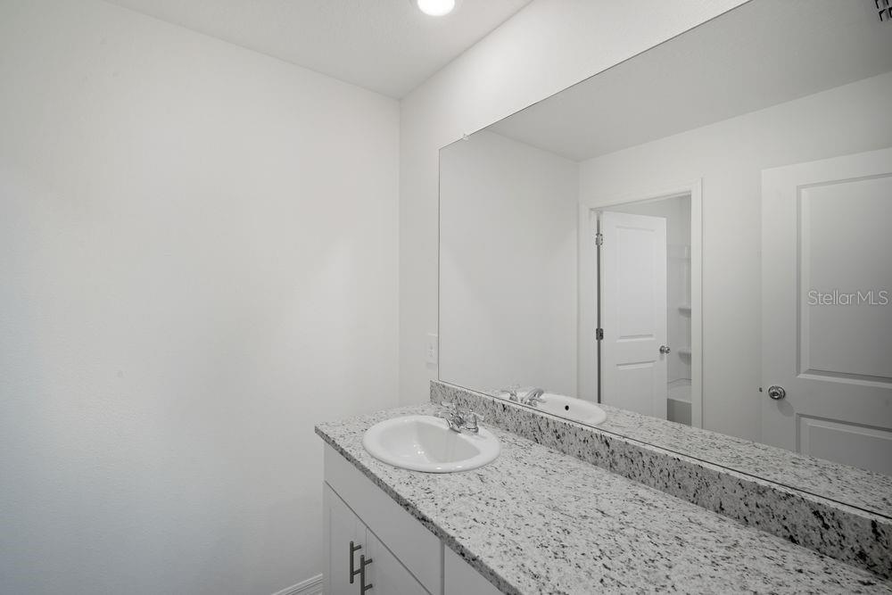 13245 Tropical Breeze Way Hudson, FL 34669 - Photo 19 of 41 a bathroom with a granite countertop sink and a mirror
