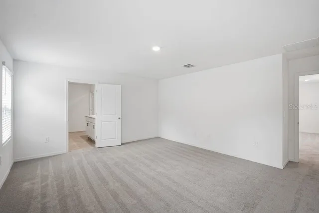 a view of an empty room with wooden floor and closet