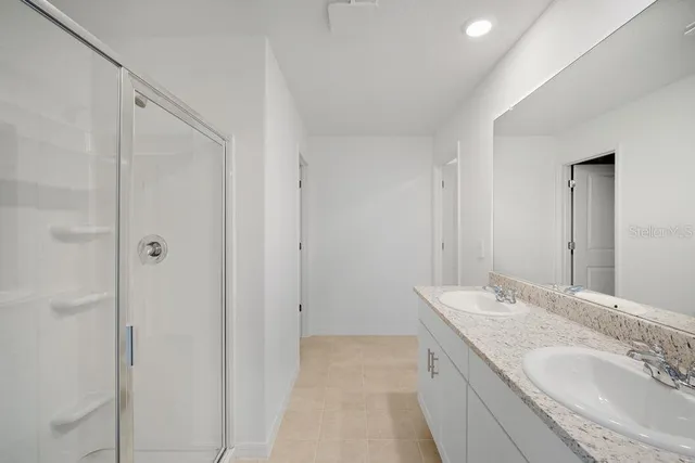a bathroom with a granite countertop sink a mirror and a shower