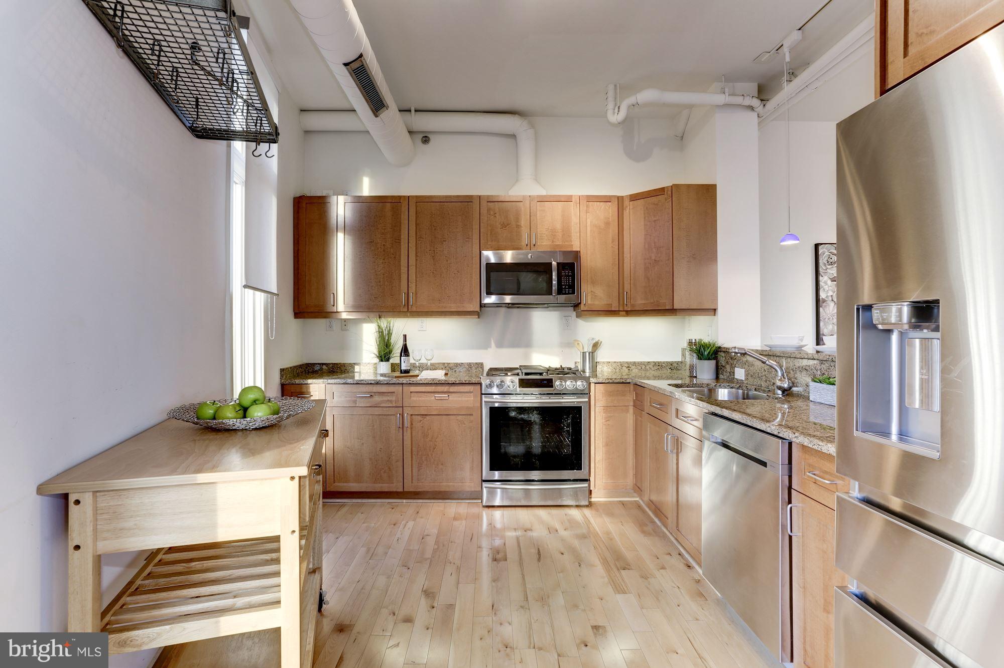 1700 Kalorama Road Northwest, Unit 312 Washington, DC 20009 - Photo 14 of 45 a kitchen with stainless steel appliances kitchen island granite countertop a stove sink and refrigerator
