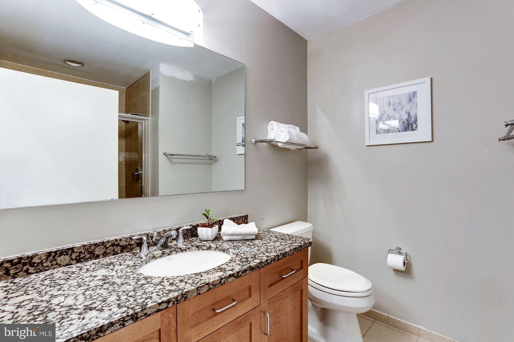 1700 Kalorama Road Northwest, Unit 312 Washington, DC 20009 - Photo 24 of 45 a bathroom with a granite countertop toilet and a sink