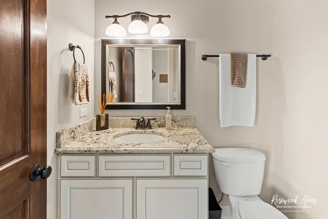 a bathroom with a granite countertop sink and a mirror