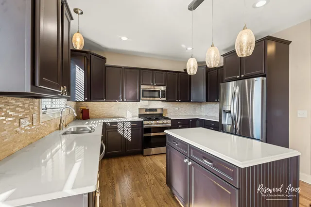 a kitchen with stainless steel appliances granite countertop a sink refrigerator and microwave