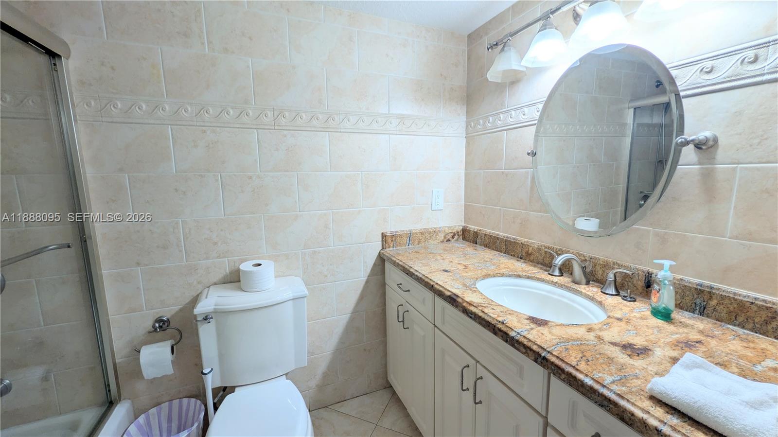 3090 North Course Drive, Unit 304 Pompano Beach, FL 33069 - Photo 12 of 13 a bathroom with a granite countertop sink mirror vanity and toilet
