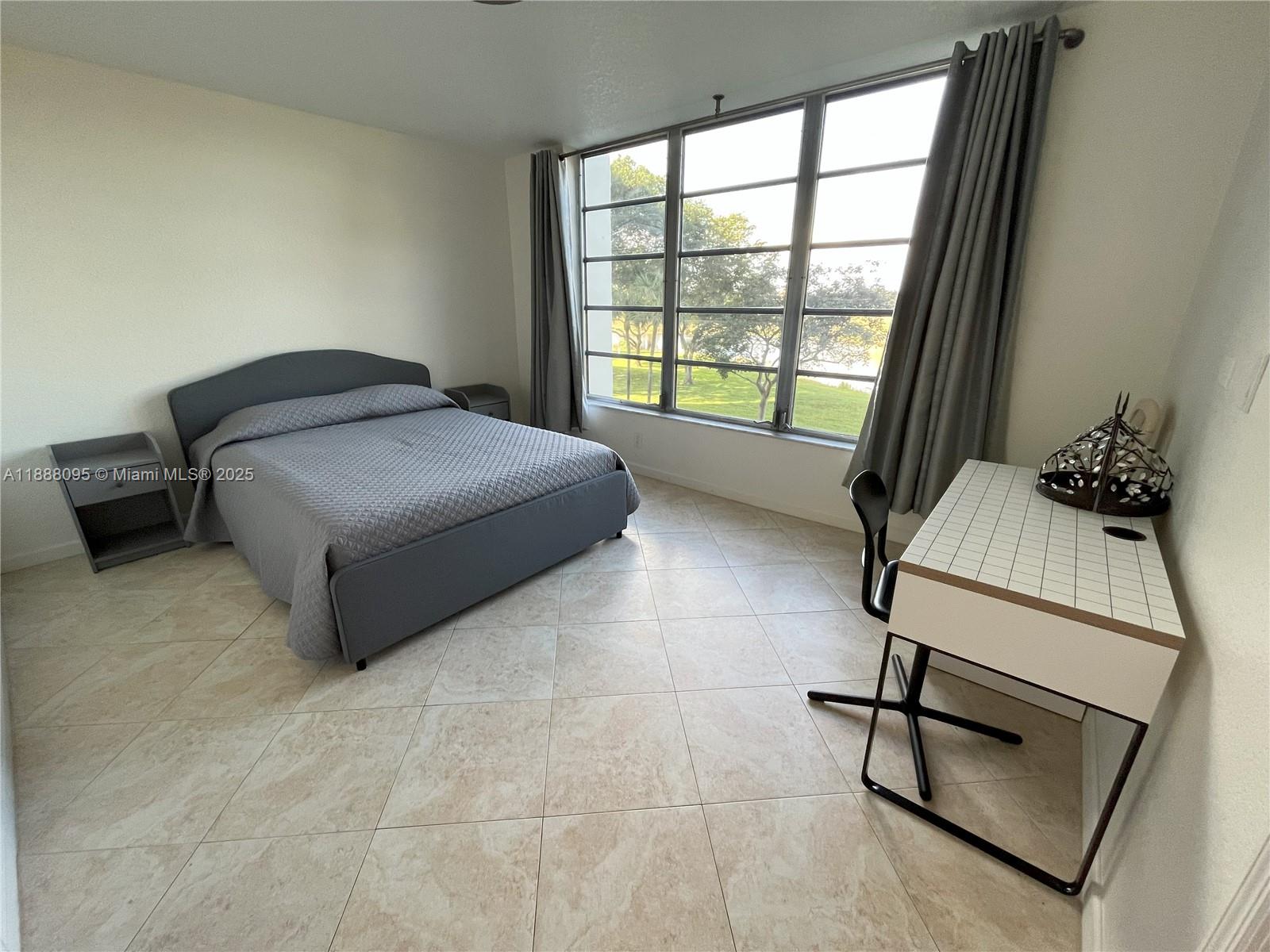 3090 North Course Drive, Unit 304 Pompano Beach, FL 33069 - Photo 13 of 16 a bedroom with a bed and a window