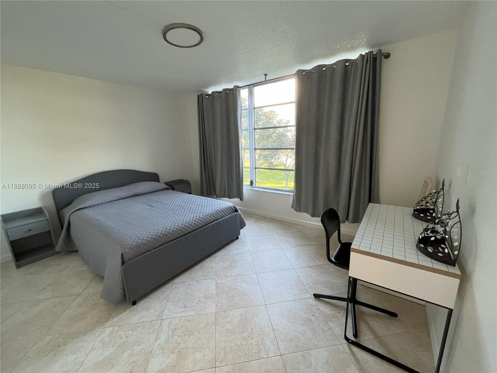 3090 North Course Drive, Unit 304 Pompano Beach, FL 33069 - Photo 14 of 16 a bedroom with a bed and a window