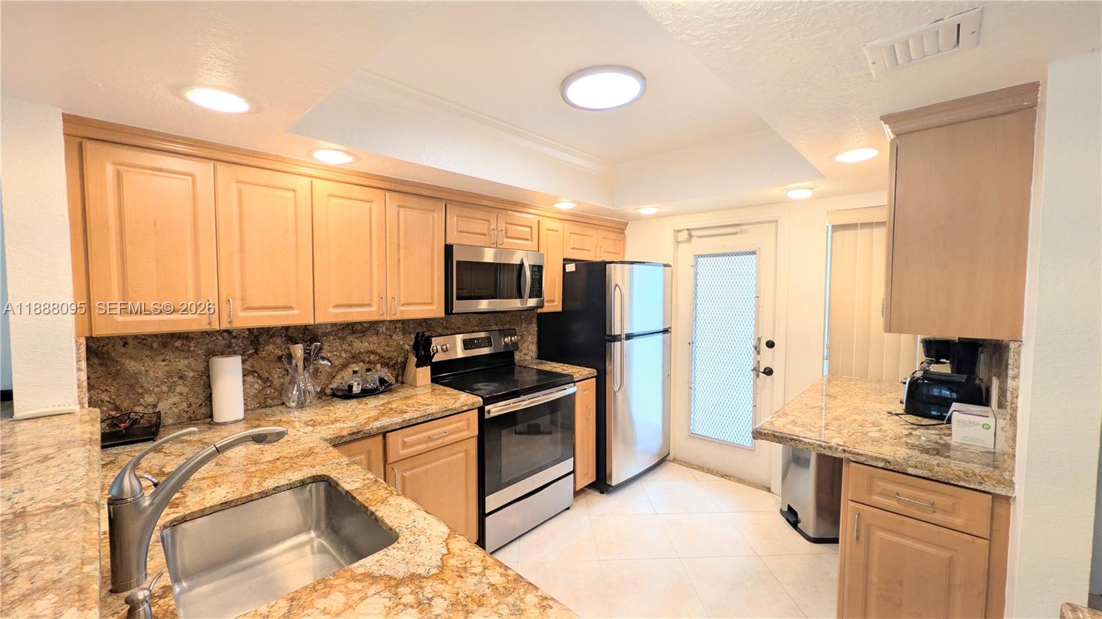 3090 North Course Drive, Unit 304 Pompano Beach, FL 33069 - Photo 2 of 13 a kitchen with stainless steel appliances granite countertop a sink stove and refrigerator