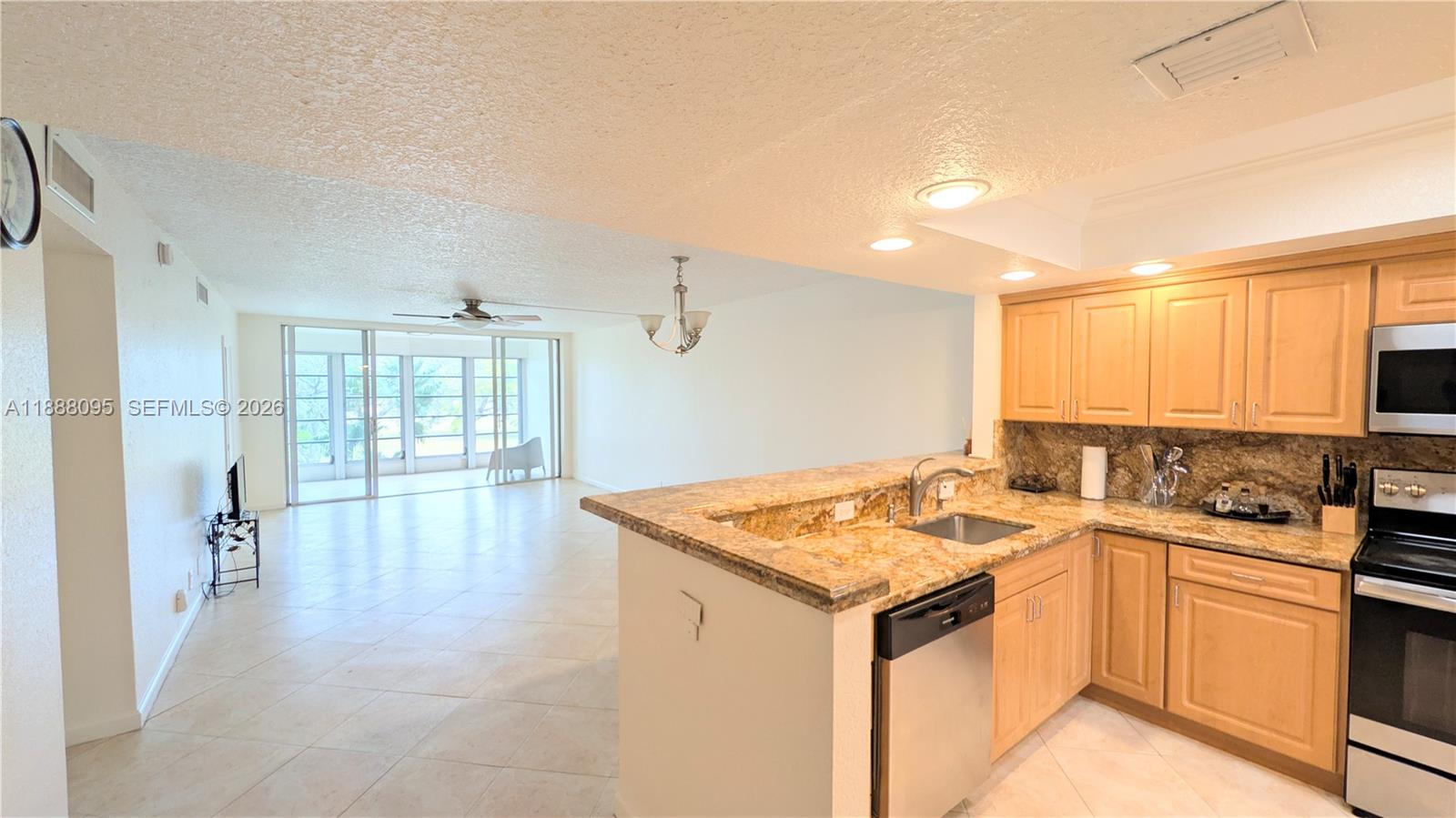 3090 North Course Drive, Unit 304 Pompano Beach, FL 33069 - Photo 4 of 13 a kitchen with a sink stove and cabinets