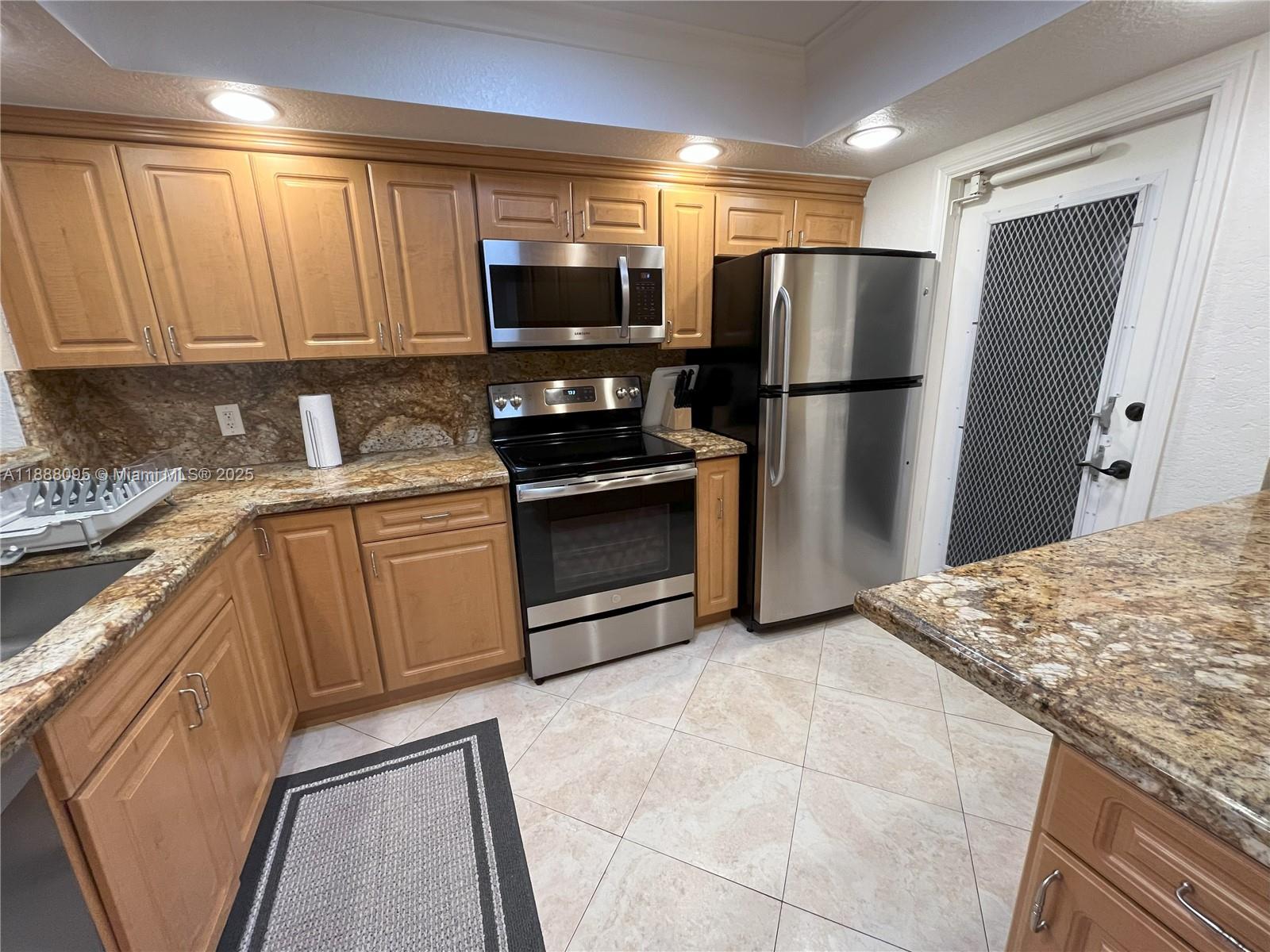 3090 North Course Drive, Unit 304 Pompano Beach, FL 33069 - Photo 4 of 16 a kitchen with stainless steel appliances granite countertop a refrigerator stove a sink and dishwasher