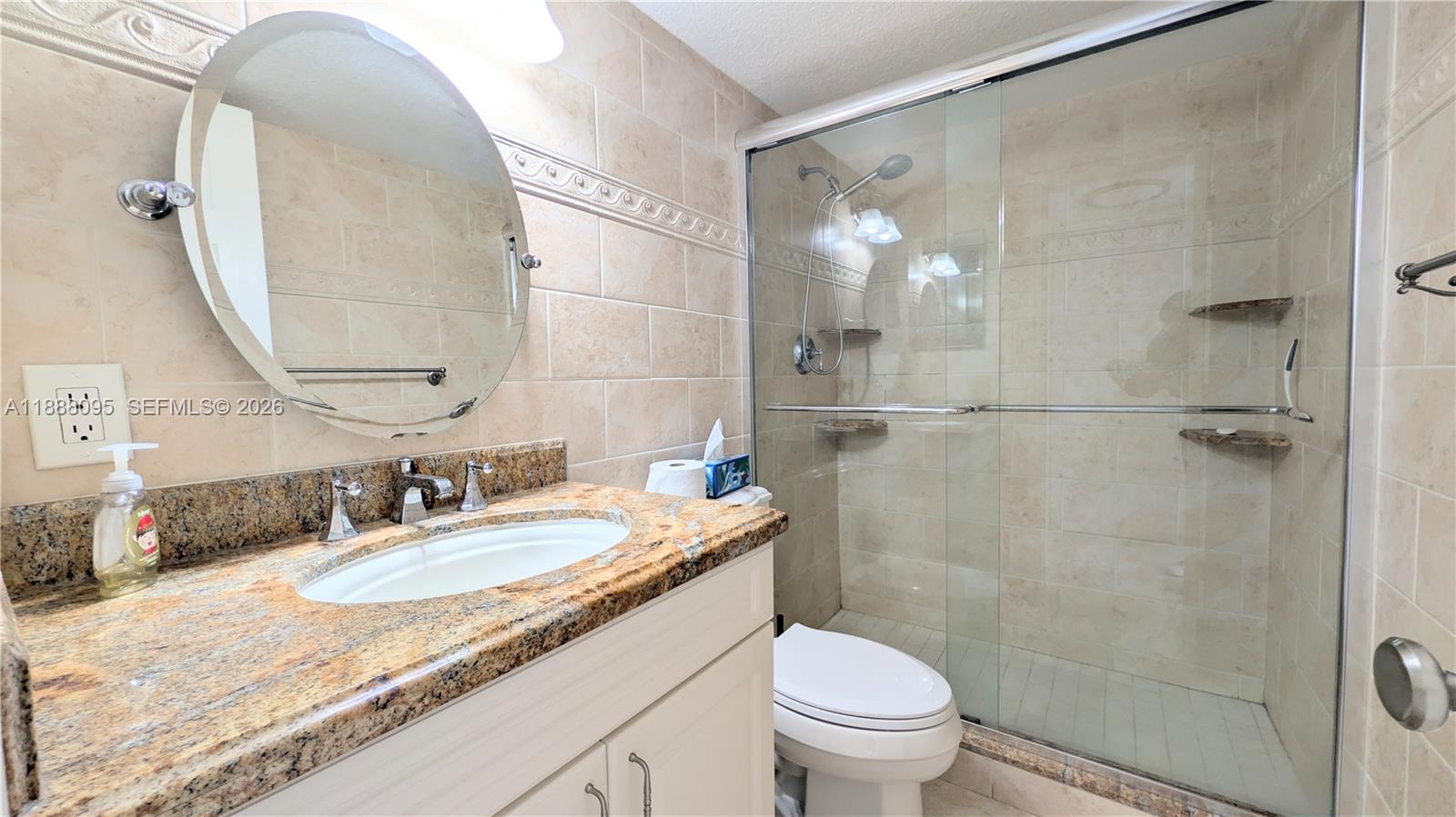 3090 North Course Drive, Unit 304 Pompano Beach, FL 33069 - Photo 9 of 13 a bathroom with a granite countertop sink a toilet and shower