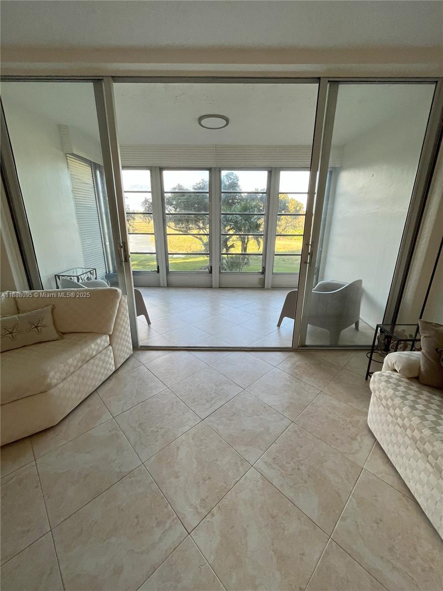 3090 North Course Drive, Unit 304 Pompano Beach, FL 33069 - Photo 9 of 16 a living room with a couch and a large window